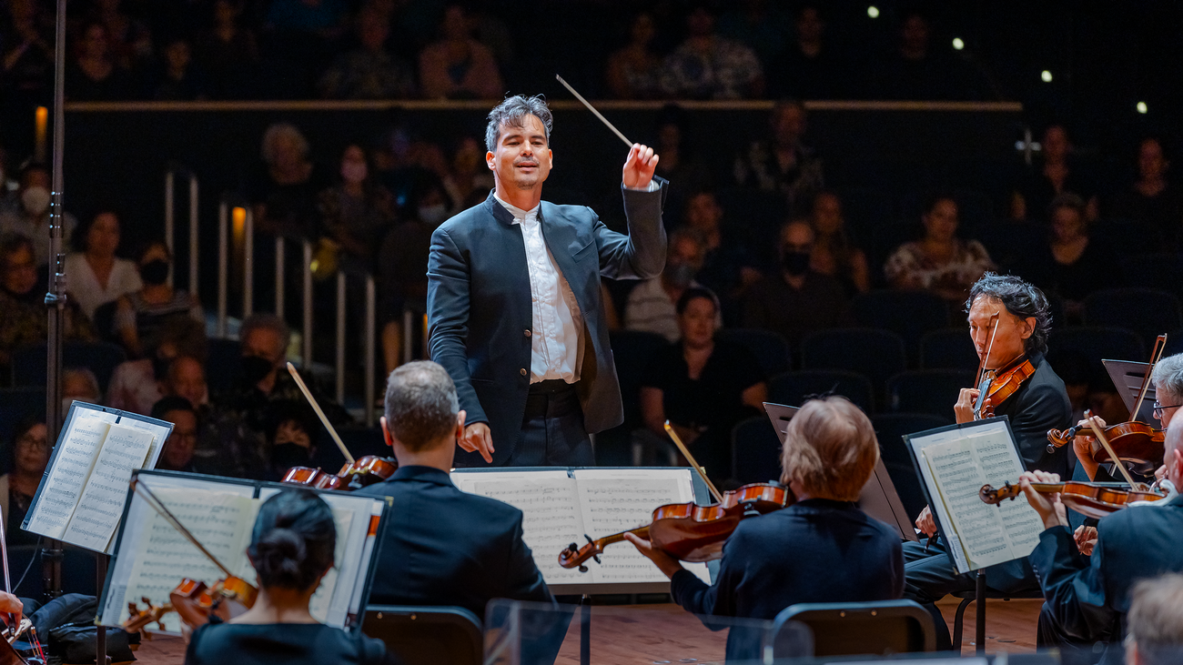 A conductor in front of an orchestra