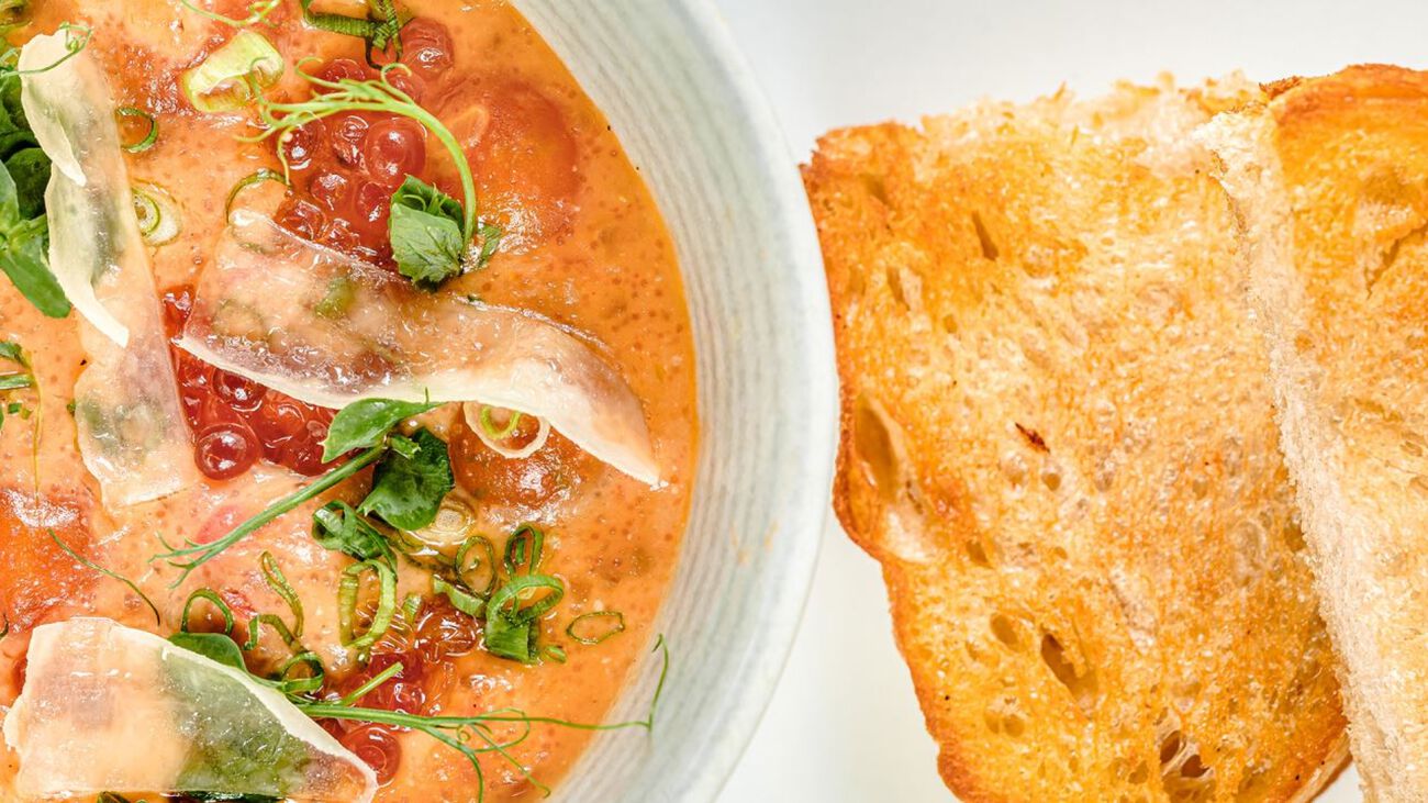 Bowl of soup with a side of bread.