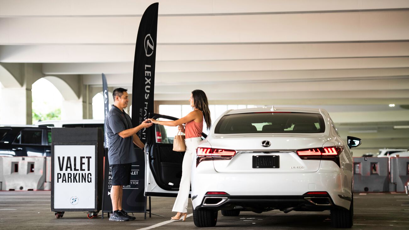 A woman gives the keys to her Lexus car to the valet at Ala Moana Shopping Center.