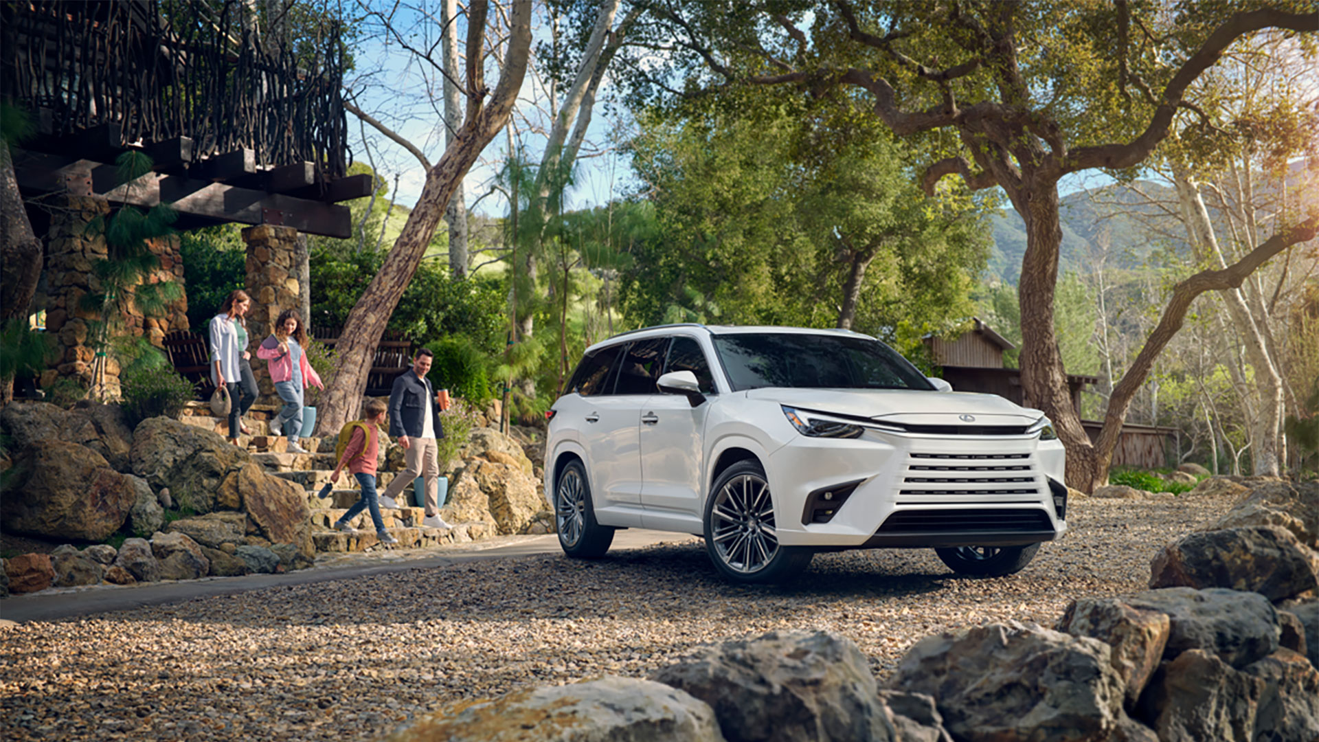 2025 Lexus TX 500 Hybrid Wind Chill Pearl with a family walking towards it