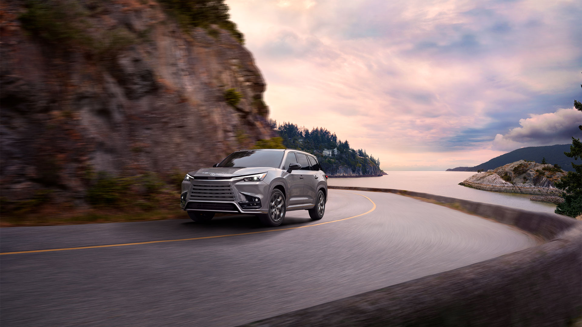 2025 Lexus TX 500 Hybrid Incognito driving on a curved roadway