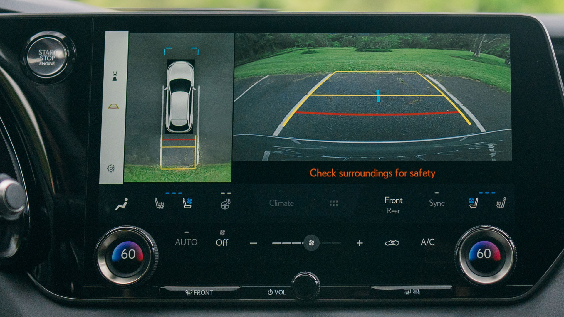 Focus on vehicle tablet display showing surroundings and panoramic view while backing up.