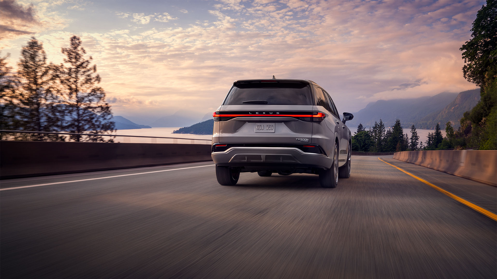 2026 Lexus TX 350 shown in Celestial Silver Metallic driving on a curved roadway