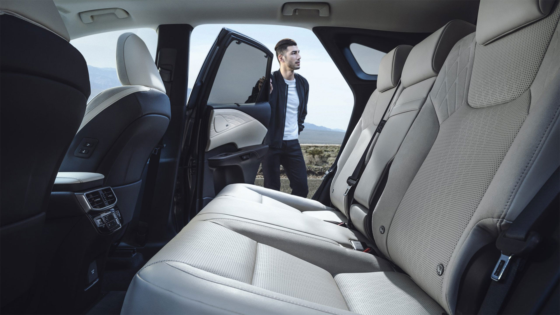 2025 Lexus RX 350 Hybrid with Birch leather and Black Open-Pore Wood trim, interior view of man holding door open while looking around