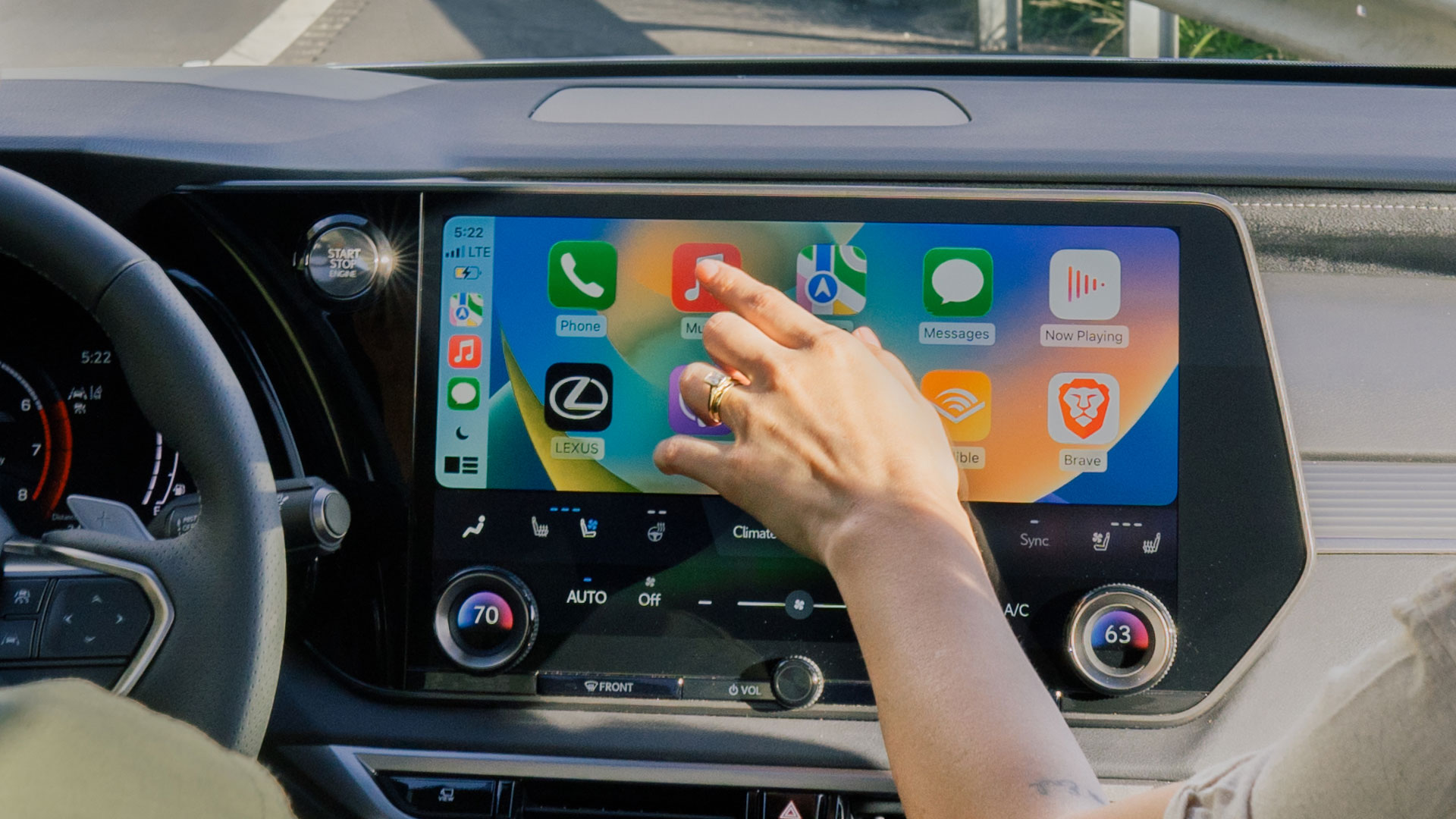 Man and woman seated in cars front seats looking at apple carplay display