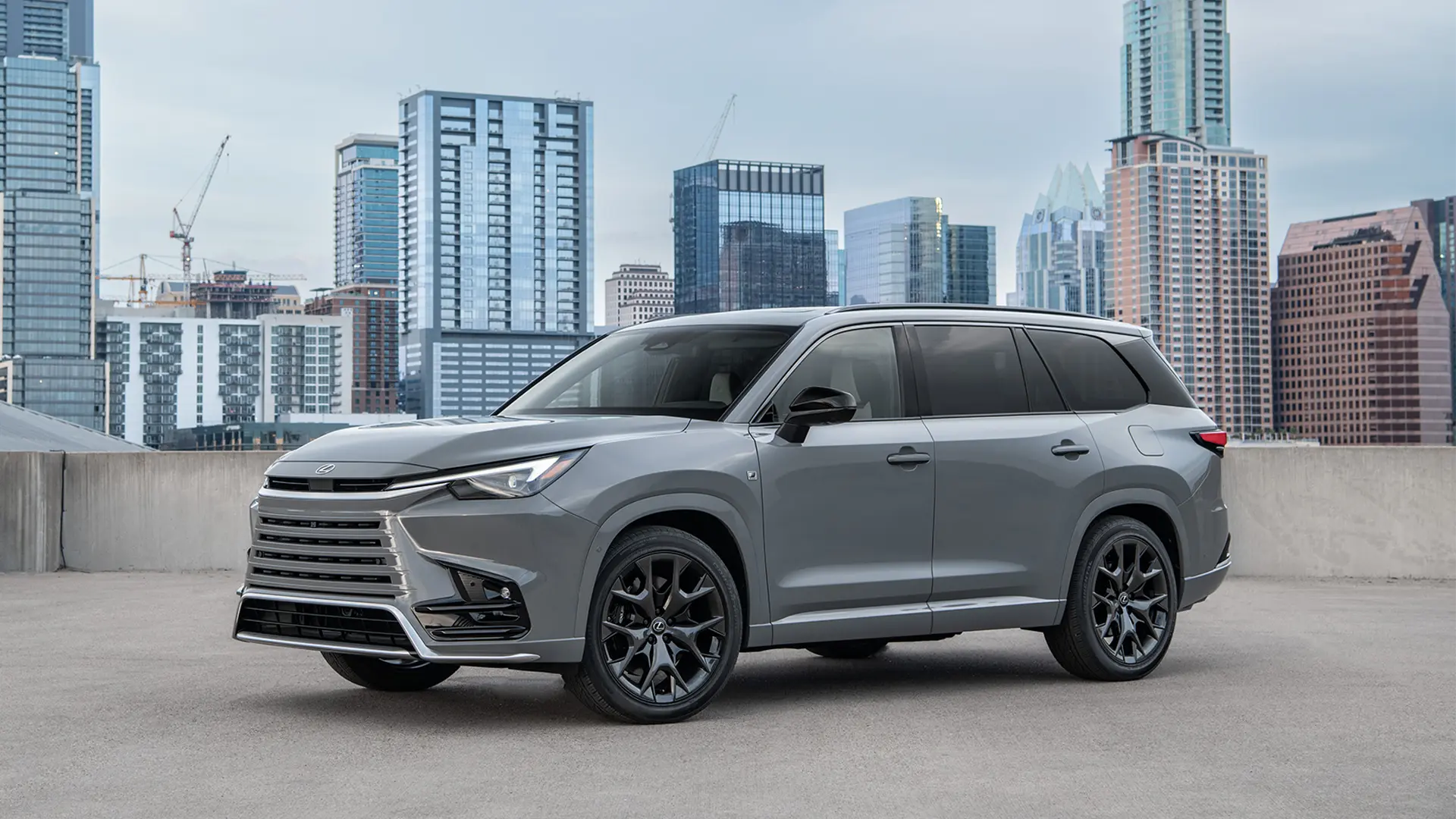 TX 500h F SPORT parked in front of cityscape.